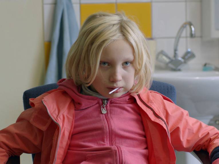 Zu sehen ist ein kleines kind das in einem stuhl sitzt und ein gespräch führt.